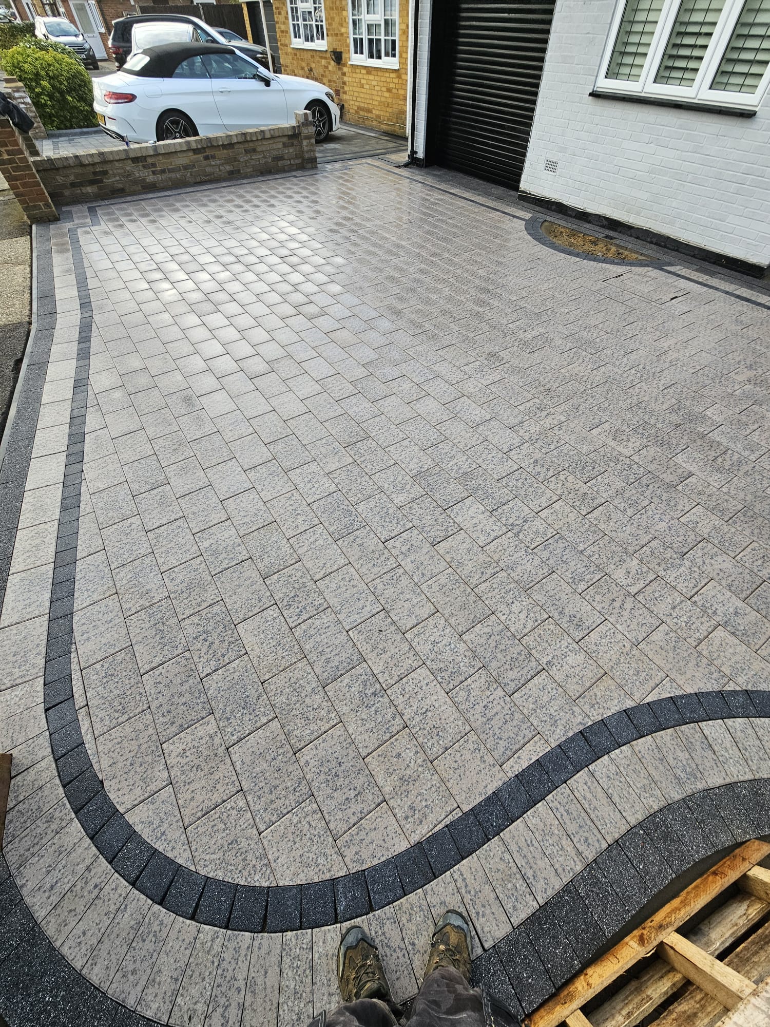 Grey paved driveway finished with a curved charcoal border