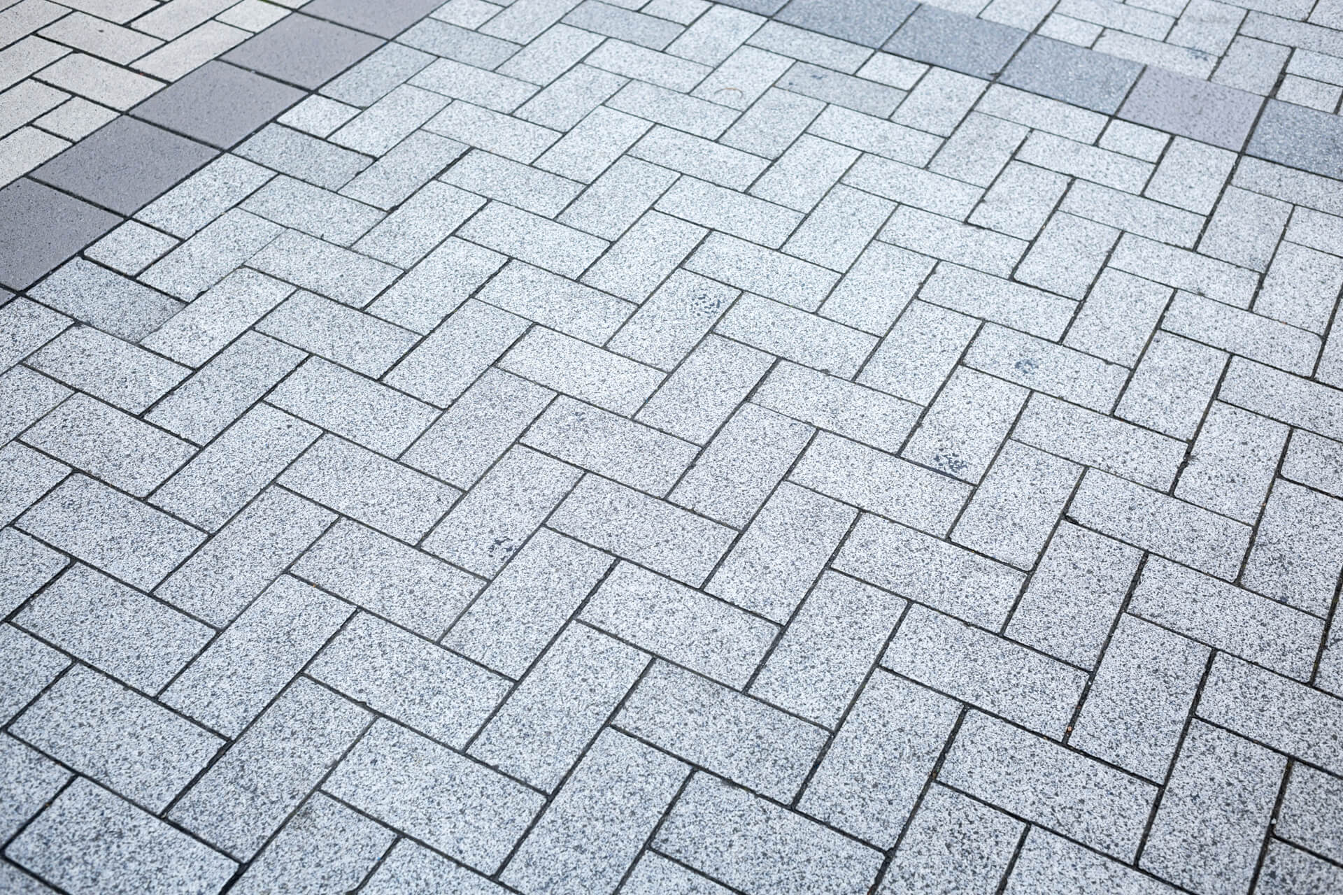 Light grey rectangular paving blocks with charcoal accents